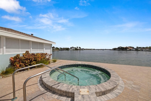 view of swimming pool featuring an in ground hot tub and a water view