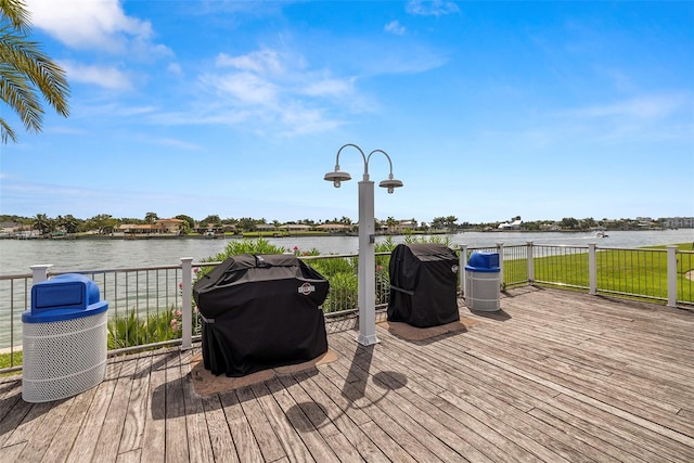 wooden deck with a water view and area for grilling