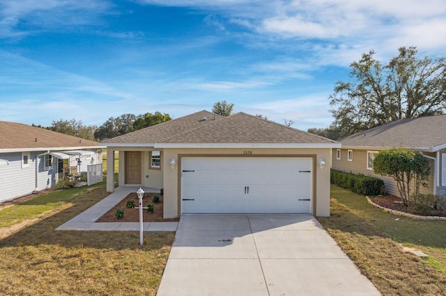 ranch-style home featuring stucco siding, a shingled roof, a garage, driveway, and a front lawn