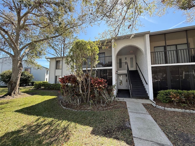 entrance to property with a lawn and stucco siding