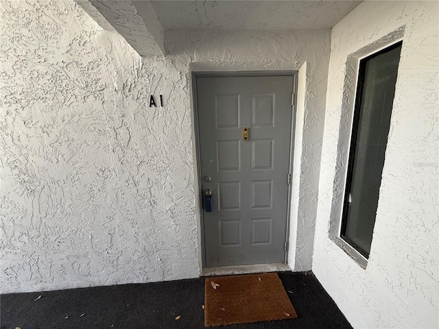 view of exterior entry with stucco siding