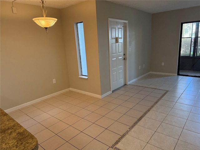 entrance foyer with light tile patterned flooring and baseboards