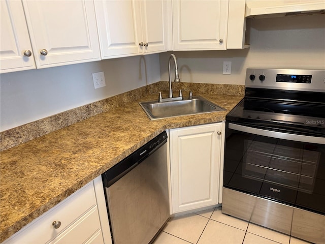 kitchen with under cabinet range hood, white cabinetry, appliances with stainless steel finishes, and a sink