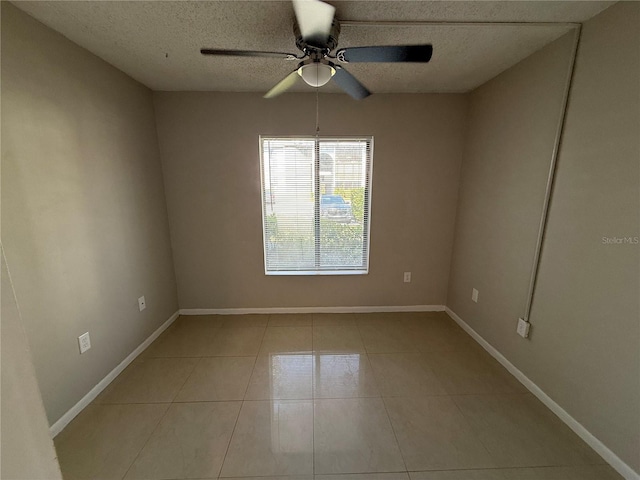 unfurnished room featuring a ceiling fan, baseboards, a textured ceiling, and light tile patterned flooring