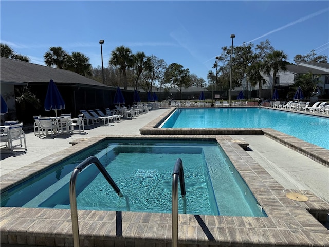 community pool with a patio area and fence