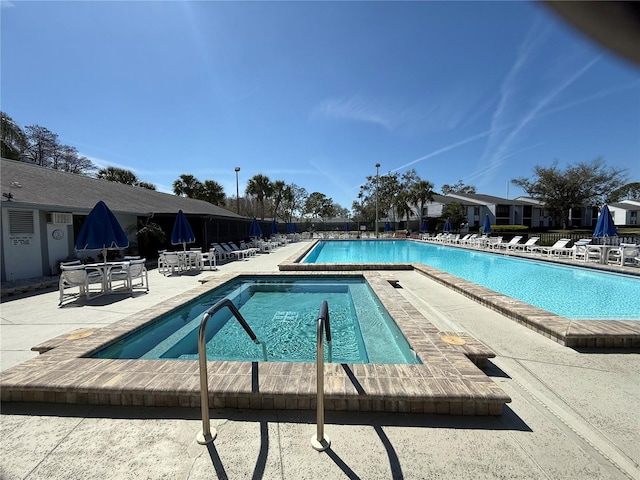 community pool with a patio and fence