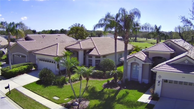 view of front facade with driveway, an attached garage, a front lawn, and stucco siding