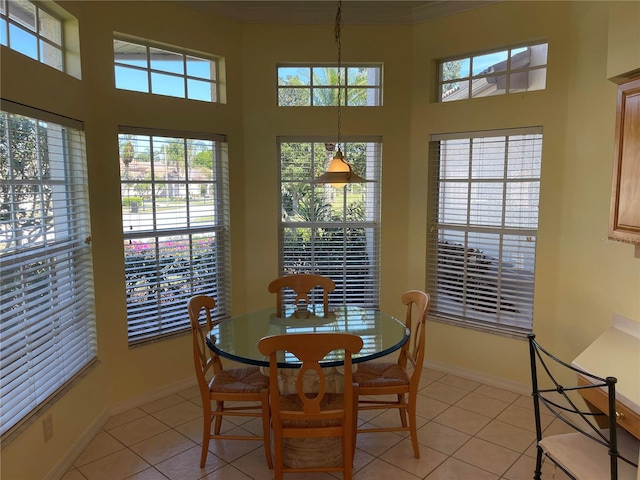 dining area featuring a high ceiling, baseboards, and light tile patterned floors