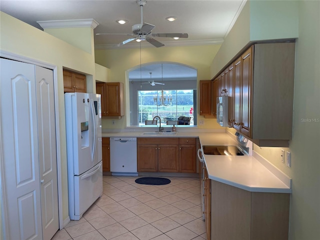 kitchen with crown molding, light countertops, brown cabinetry, a sink, and white appliances