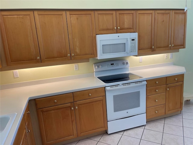 kitchen with white appliances, light tile patterned floors, and brown cabinets