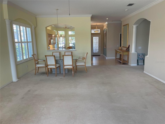 carpeted dining area with ornate columns, visible vents, a sink, and ornamental molding