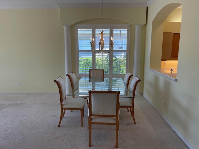 dining area featuring a chandelier, baseboards, decorative columns, and light colored carpet