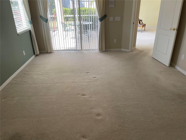 carpeted empty room with baseboards