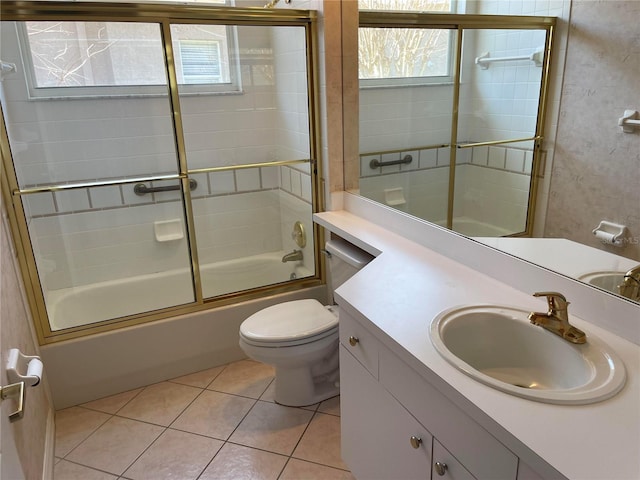 bathroom featuring combined bath / shower with glass door, vanity, toilet, and tile patterned floors