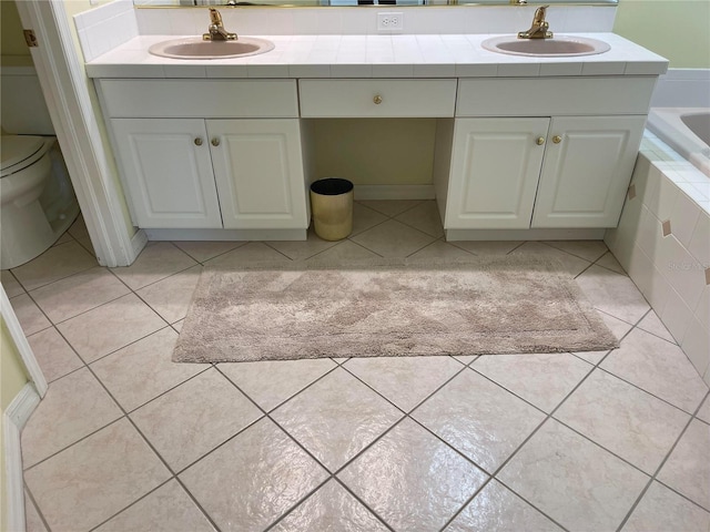 bathroom with double vanity, a sink, and tile patterned floors