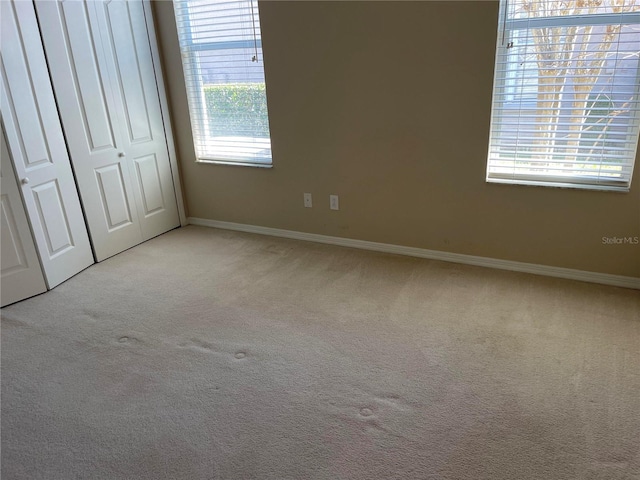 unfurnished bedroom with a closet, baseboards, and carpet flooring