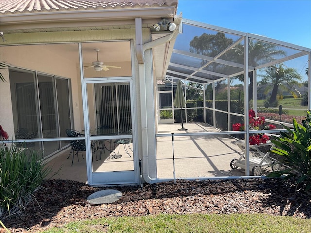 view of patio / terrace featuring glass enclosure and ceiling fan