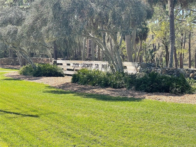 community sign with a lawn and a wooded view