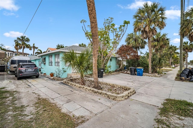 view of side of home with concrete driveway and stucco siding