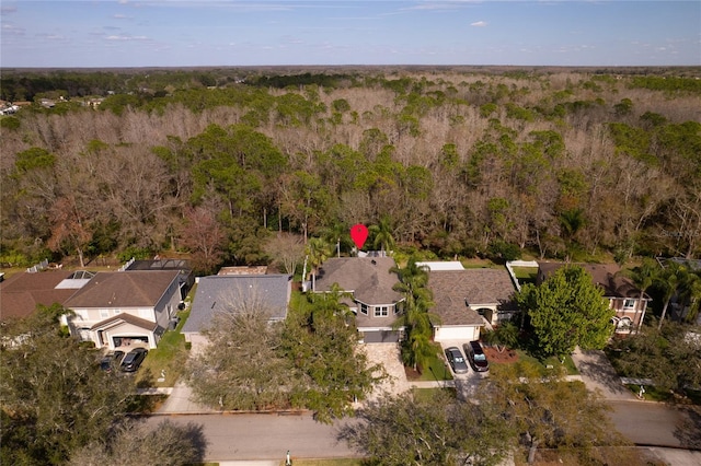 drone / aerial view with a wooded view and a residential view