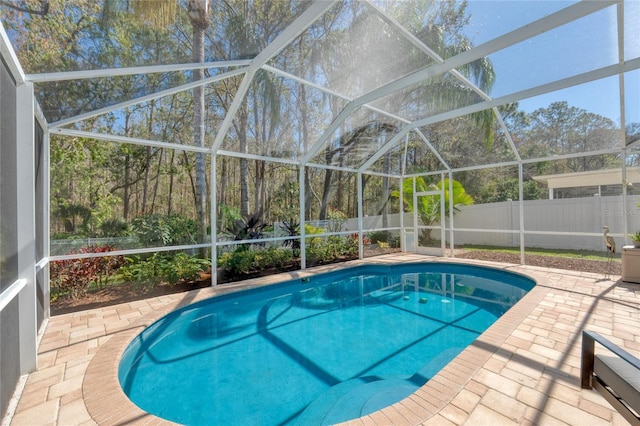 view of swimming pool featuring a patio area, a fenced backyard, and glass enclosure