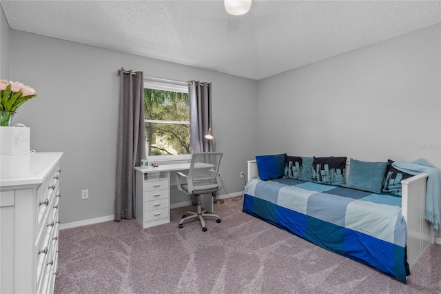 carpeted bedroom featuring a textured ceiling and baseboards