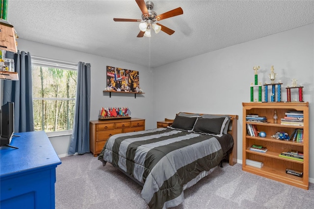 bedroom featuring a ceiling fan, light carpet, a textured ceiling, and baseboards