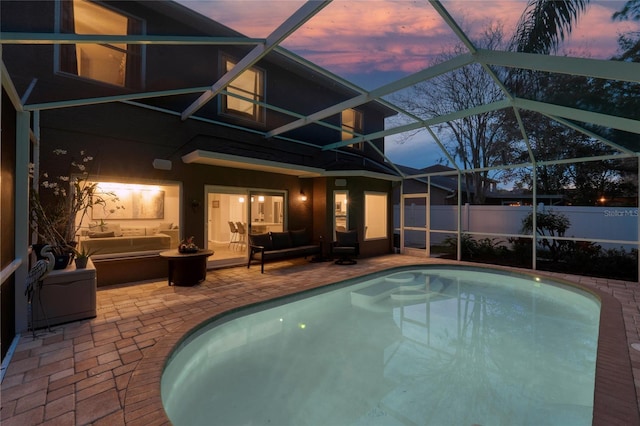 view of swimming pool featuring glass enclosure, fence, a fenced in pool, and a patio