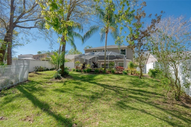 view of yard featuring glass enclosure and a fenced backyard