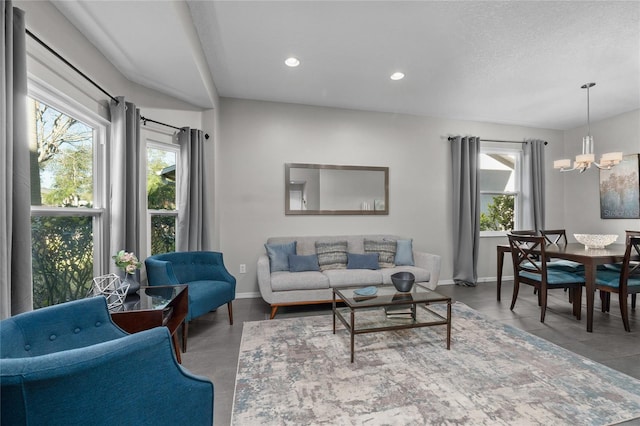 living area featuring a chandelier, a wealth of natural light, and baseboards