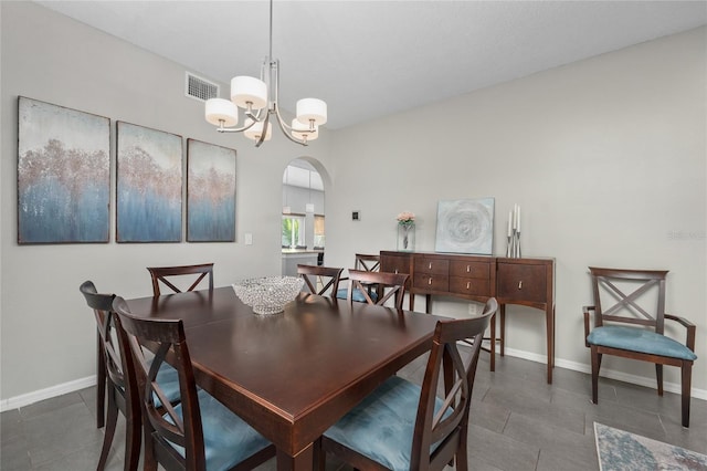 dining room featuring arched walkways, visible vents, baseboards, and an inviting chandelier