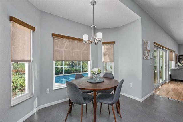 dining space featuring a notable chandelier and baseboards