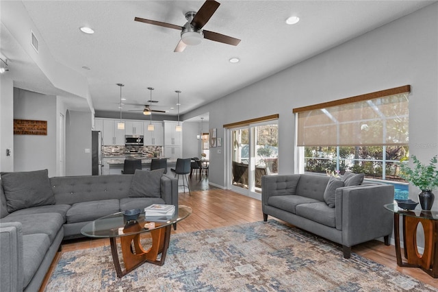 living area featuring light wood-style flooring, visible vents, a ceiling fan, and recessed lighting