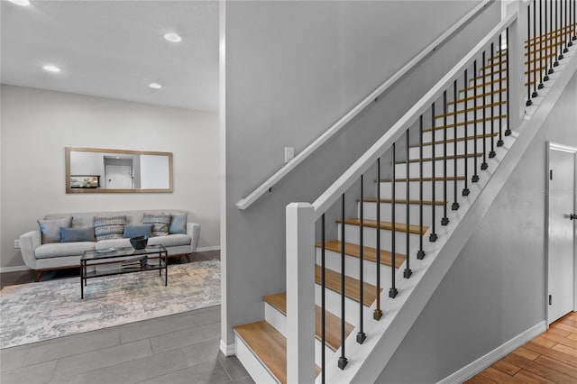 stairs with recessed lighting, wood finished floors, and baseboards