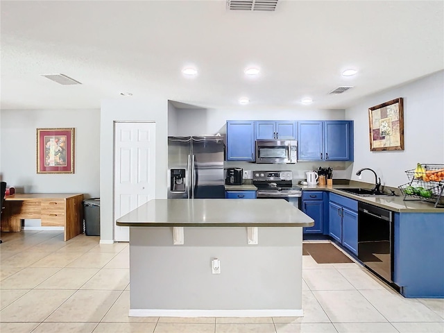 kitchen featuring appliances with stainless steel finishes, visible vents, a sink, and a kitchen island