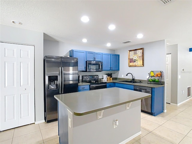 kitchen with dark countertops, a kitchen island, stainless steel appliances, and a sink