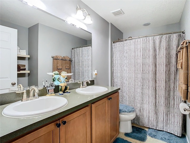 full bath with visible vents, a sink, toilet, and double vanity