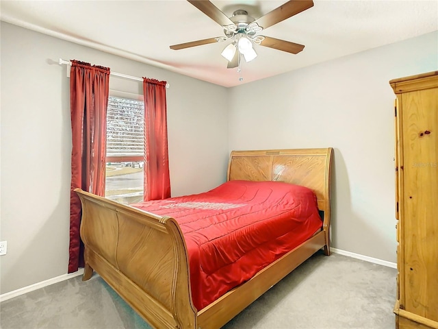 bedroom with light colored carpet, ceiling fan, and baseboards