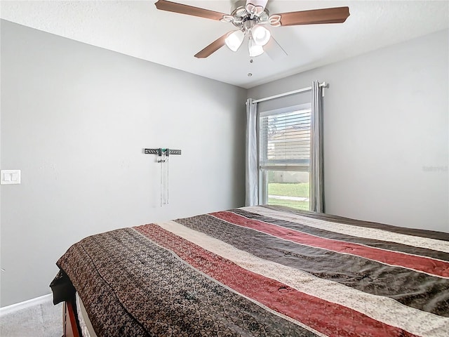 bedroom with a ceiling fan, carpet, and baseboards