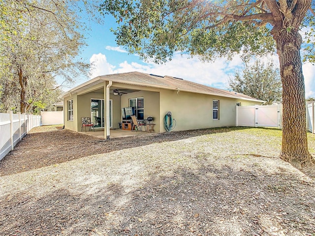 back of house with ceiling fan, a patio area, a fenced backyard, and stucco siding