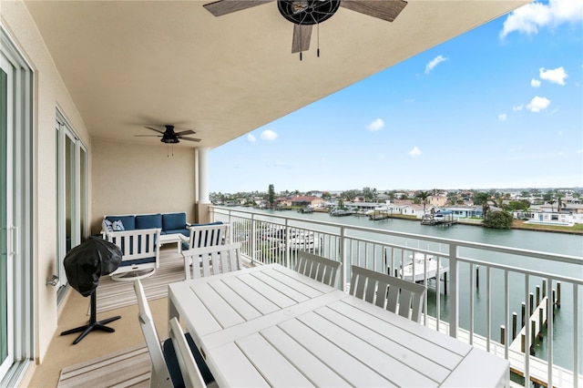 balcony featuring a water view, an outdoor living space, a ceiling fan, and outdoor dining space