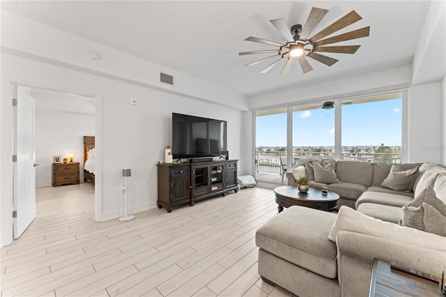 living area featuring visible vents, ceiling fan, light wood-style flooring, and baseboards