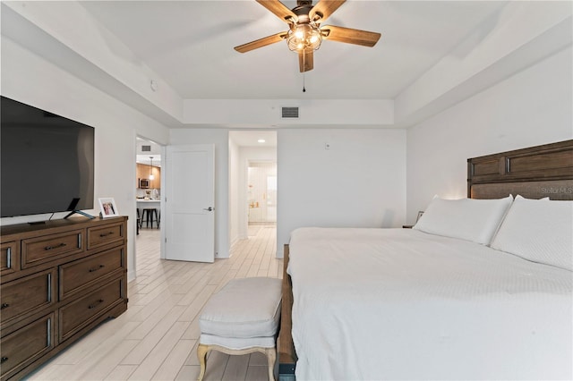 bedroom featuring ceiling fan, light wood-type flooring, connected bathroom, and visible vents