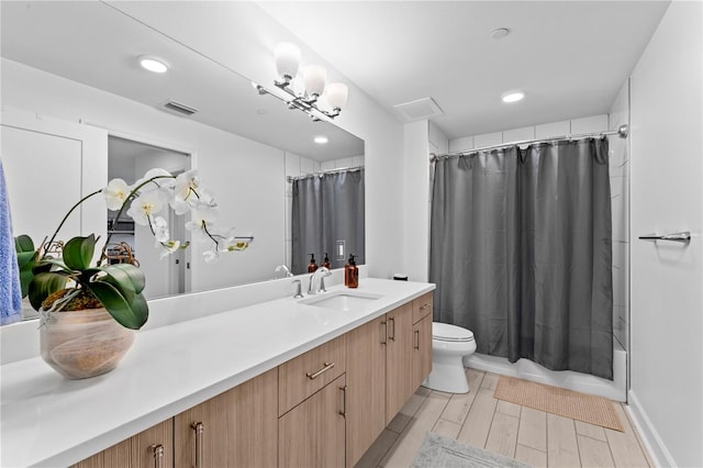 bathroom featuring visible vents, toilet, shower / tub combo, wood tiled floor, and vanity