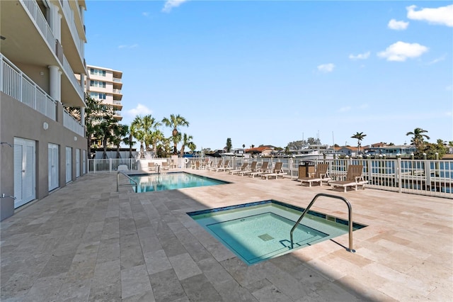 community pool featuring a community hot tub, a patio, and fence