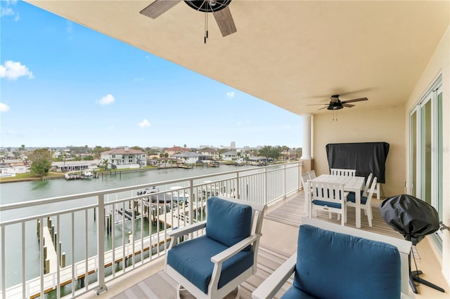 balcony featuring a water view and ceiling fan