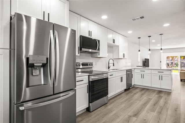 kitchen with stainless steel appliances, white cabinets, visible vents, and a peninsula