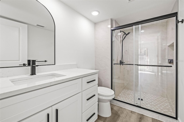 2101 Cordova Grn, Seminole, FL 33777 - bathroom with a stall shower, vanity, toilet, and wood finished floors