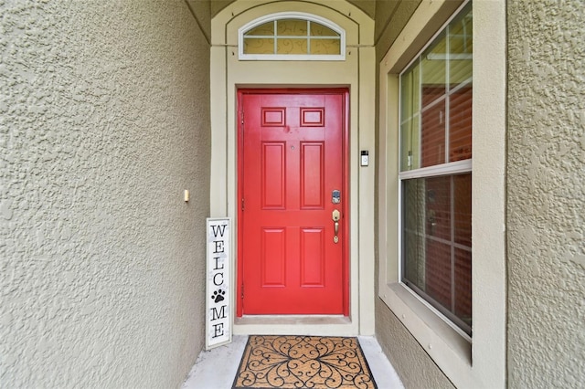 view of exterior entry featuring stucco siding