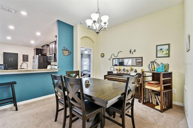 dining area featuring arched walkways, visible vents, light carpet, and baseboards